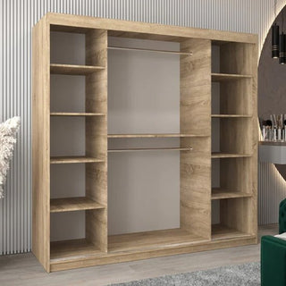 The Vevey II Mirrored Wardrobe with 2 sliding doors and multiple shelves stands against a light-colored, vertically-lined wall in a modern room. It features Sonoma Oak finish and is 200cm wide with two horizontal hanging rods in the center.