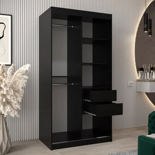 The Vevey III Mirrored Wardrobe with 2 sliding doors, featuring two hanging rods, four shelves, and two open drawers in black, stands in a modern room with light wood floors, striped wall panels, pampas grass, and a round mirror.