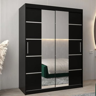 The Vevey III Mirrored Wardrobe 2 Sliding Doors 150cm in Black stands against a striped wall, its mirrored panels reflecting a bed with a green blanket and an illuminated headboard in this modern bedroom.
