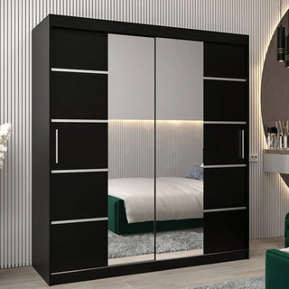 The Vevey III Mirrored Wardrobe with 2 sliding doors in black (180cm) stands in a modern bedroom with a bed, green rug, and a wall of vertical stripes.