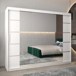 The Vevey III Mirrored Wardrobe with 3 sliding doors (250cm, white) stands in a modern bedroom, reflecting a green upholstered bed, gray rug, and textured vertical wall panels lit by LED lighting.