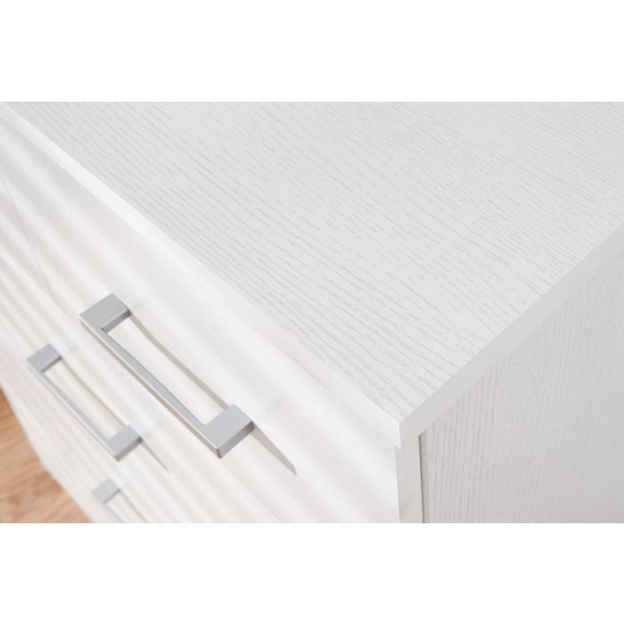 CHOICEWARDROBE PRADA white chest of drawers close-up with silver handles and wood grain texture