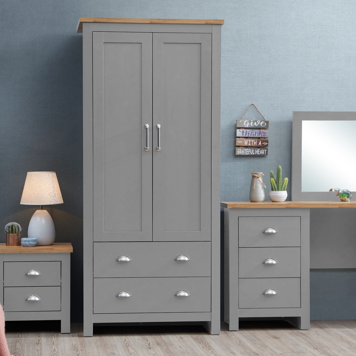 Light grey 2 door wardrobe with 2 drawers and oak effect top, shown with matching bedside table and dresser.