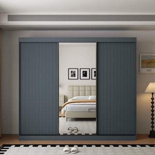 Modern dark grey 3-door sliding wardrobe with mirrored centre door, showing bedroom reflection.