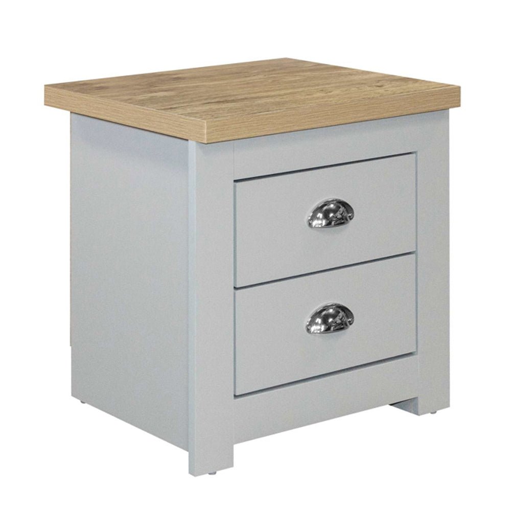 The Highland Wooden Bedside Cabinet With 2 Drawers in Grey and Oak features a chic grey body, oak top, and silver cup handles—an elegant addition that complements navy and oak bedroom décor.