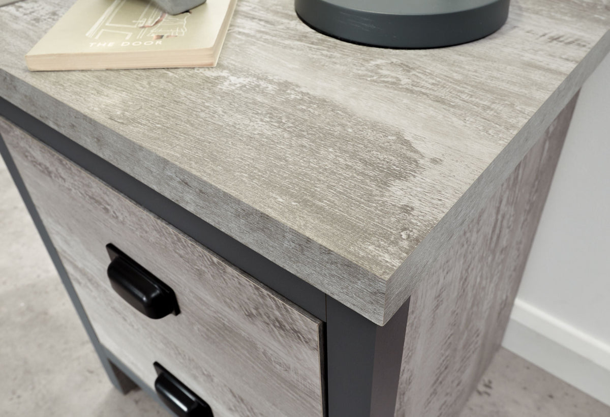 Grey wardrobe corner with distressed wood effect and black bedside drawer handle.