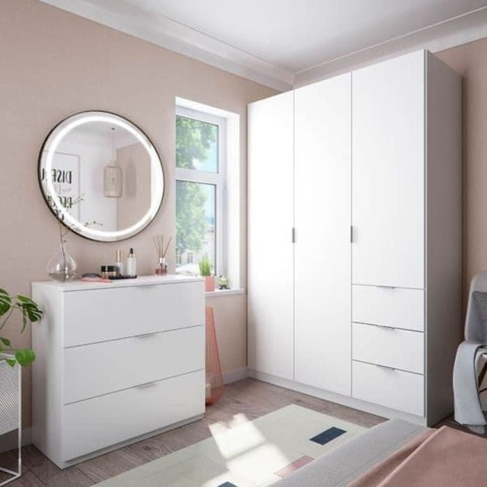 HARVEY 3 Door White Wardrobe with 3 drawers, next to a white chest of drawers and round illuminated mirror.