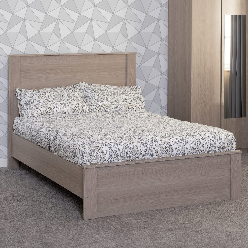 Palmyra wooden double bed frame in Smoked Ash finish with patterned bedding