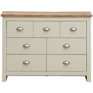 Cream 7-drawer chest with oak-effect top and silver cup handles.