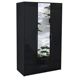 The WINSTEAD 3 Door Mirrored Wardrobe in black (135cm) offers ample storage and two drawers. Its central high gloss mirror reflects lush green plants and white shelves in the background.